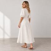 Rear three-quarter view of Cuirsy cream linen dress with puff sleeves